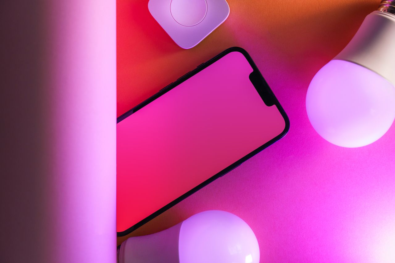 gallery-6 Colorful tech arrangement with smartphone and smart bulbs, perfect for modern design concepts.