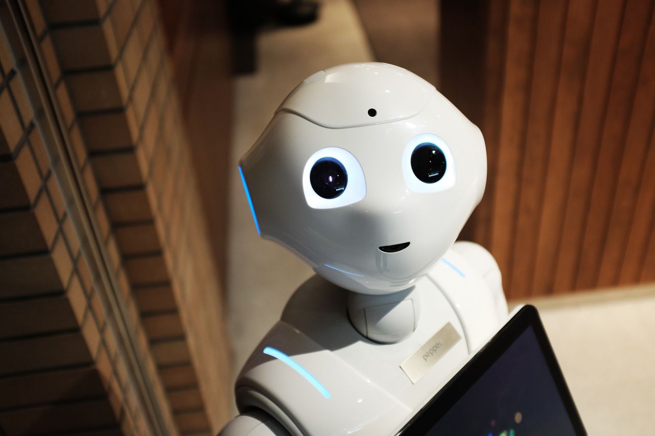 why-choose-us A futuristic humanoid robot in an indoor Tokyo setting, showcasing modern technology.
